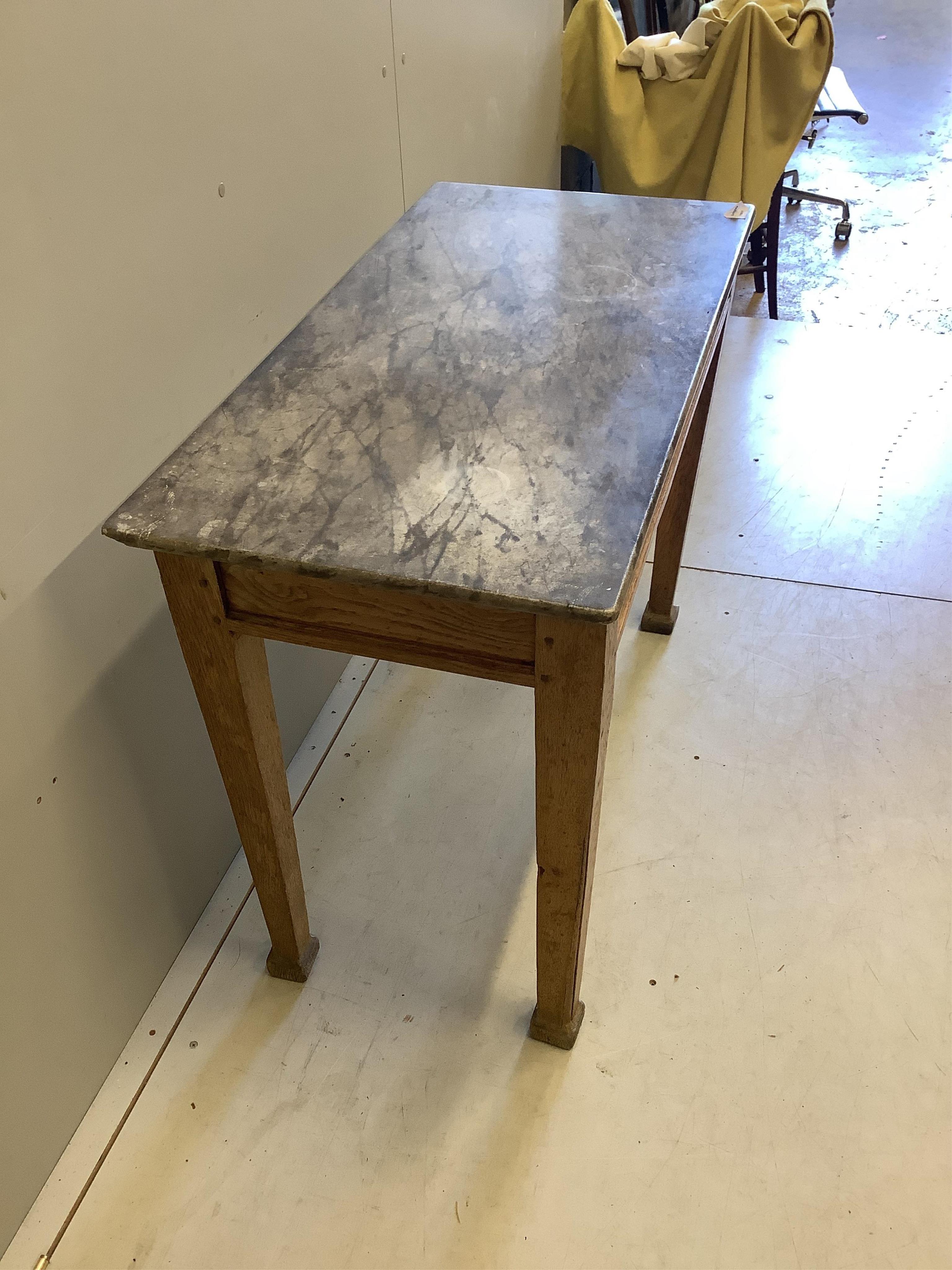 An early 20th century rectangular marble topped oak table, width 100cm, depth 49cm, height 75cm. Condition - poor to fair